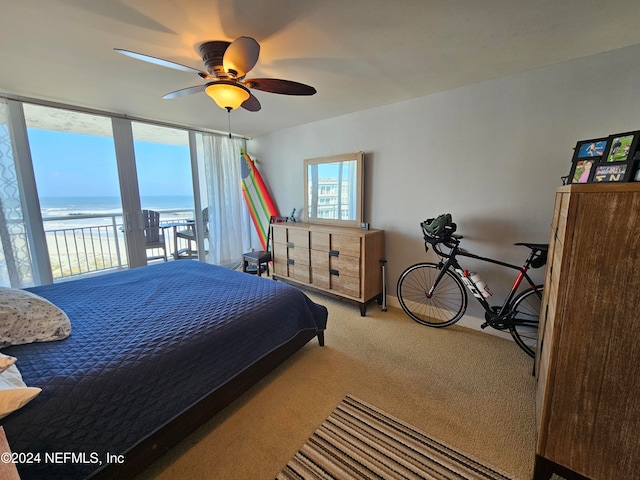 carpeted bedroom featuring a water view, ceiling fan, and access to exterior