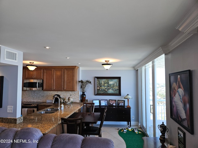 kitchen with stainless steel appliances, sink, light stone countertops, backsplash, and crown molding