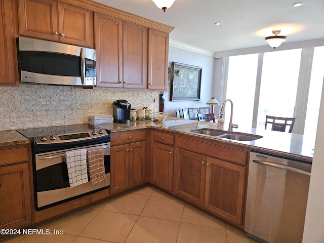 kitchen with decorative backsplash, sink, ornamental molding, and stainless steel appliances