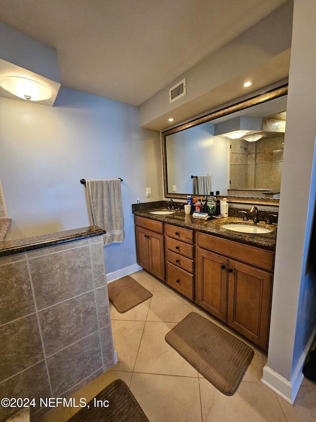 bathroom featuring vanity, tile patterned flooring, and tiled shower