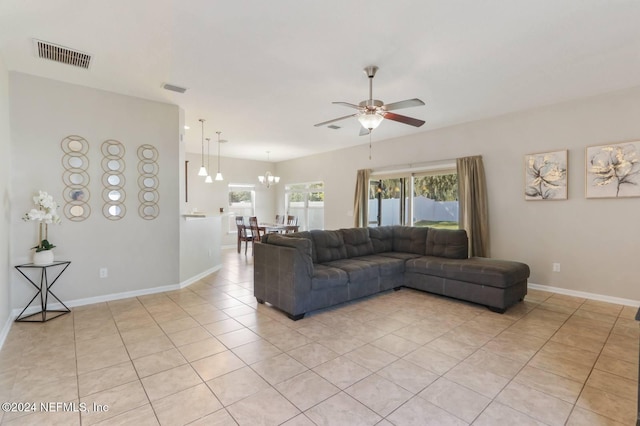 tiled living room with ceiling fan with notable chandelier