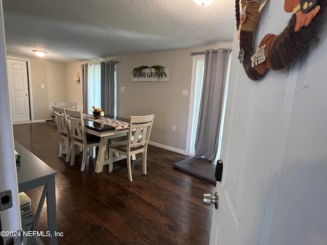 dining space featuring a textured ceiling and dark hardwood / wood-style floors