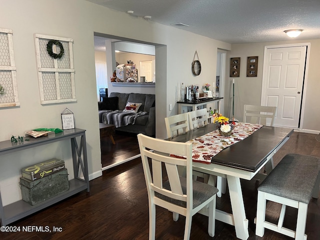 dining room with dark hardwood / wood-style flooring and a textured ceiling