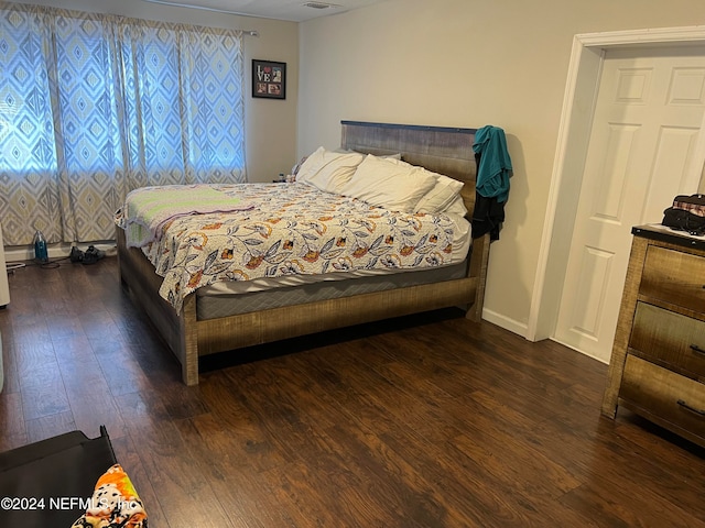 bedroom with dark hardwood / wood-style flooring