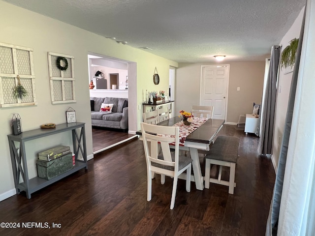 dining area featuring a textured ceiling and dark hardwood / wood-style flooring