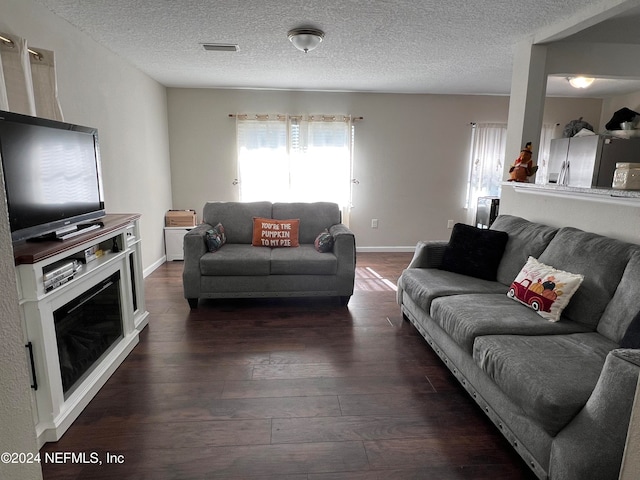 living room with dark hardwood / wood-style floors and a textured ceiling