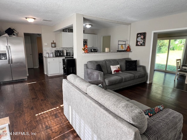 living room with dark hardwood / wood-style floors and a textured ceiling