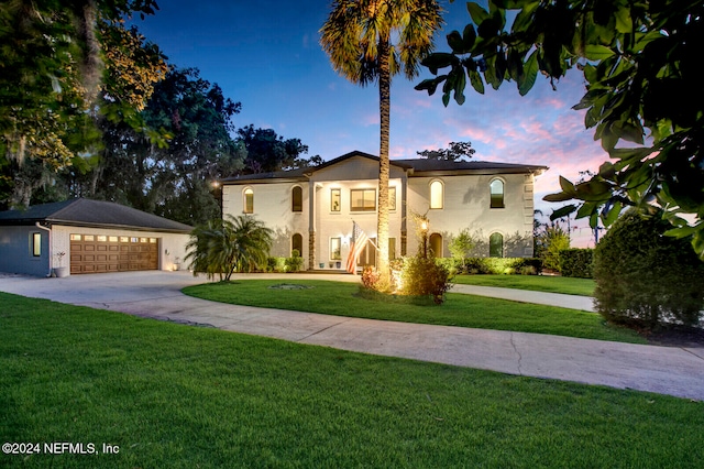 mediterranean / spanish-style house with a garage and a lawn