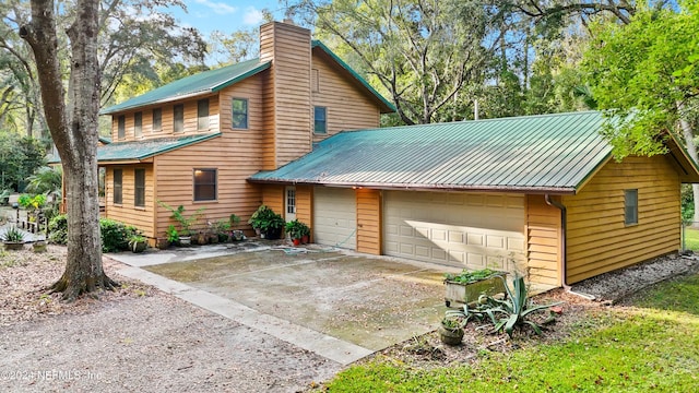 7816 Whispering Pines Ln, Glen St Mary, FL 32040 - rustic home featuring metal roof, a chimney, and a garage