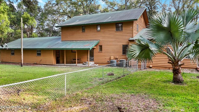 7816 Whispering Pines Ln, Glen St Mary, FL 32040 - back of house with metal roof, cooling unit, and a patio area