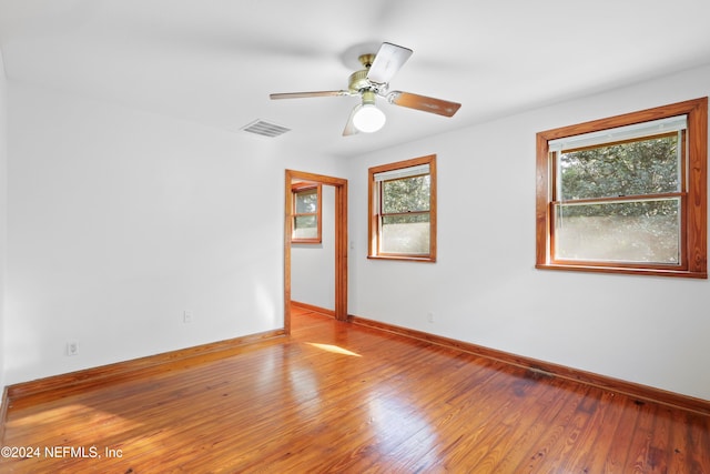 unfurnished room with hardwood / wood-style floors, ceiling fan, and plenty of natural light