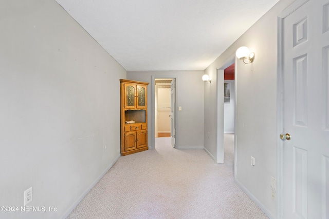 corridor featuring light colored carpet