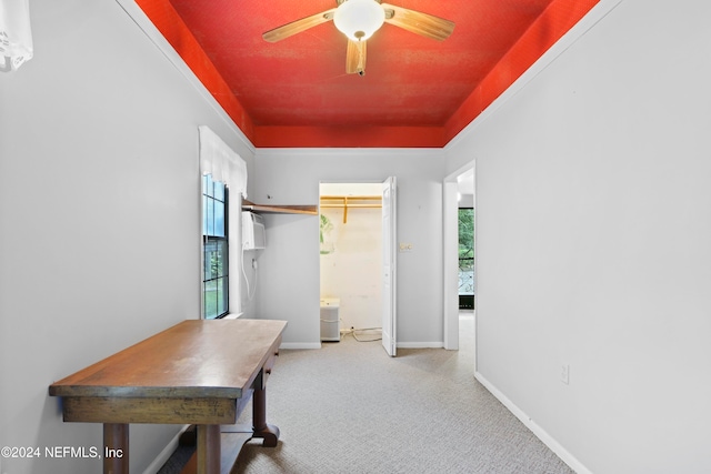 hallway featuring carpet flooring, an AC wall unit, and a healthy amount of sunlight