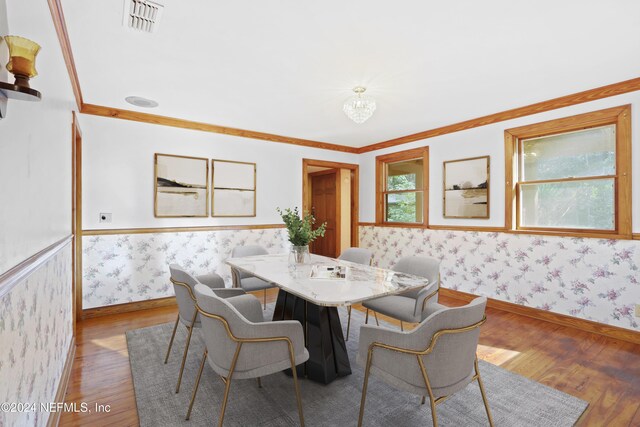 7816 Whispering Pines Ln, Glen St Mary, FL 32040 - dining space featuring wallpapered walls, wood finished floors, wainscoting, ornamental molding, and baseboards
