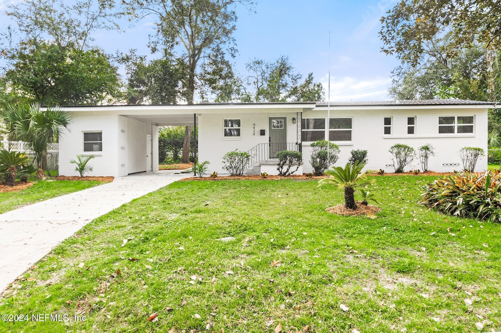 ranch-style house with a front yard and a carport