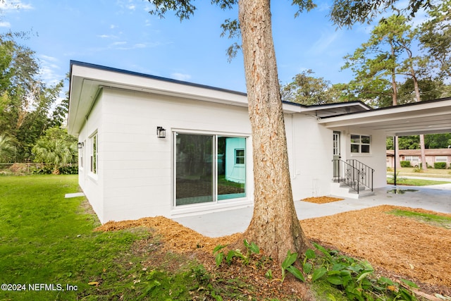 rear view of house featuring a yard and a carport