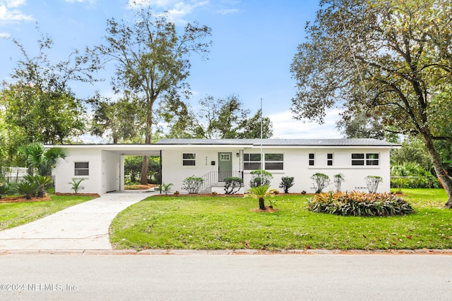 view of front facade with a carport and a front lawn