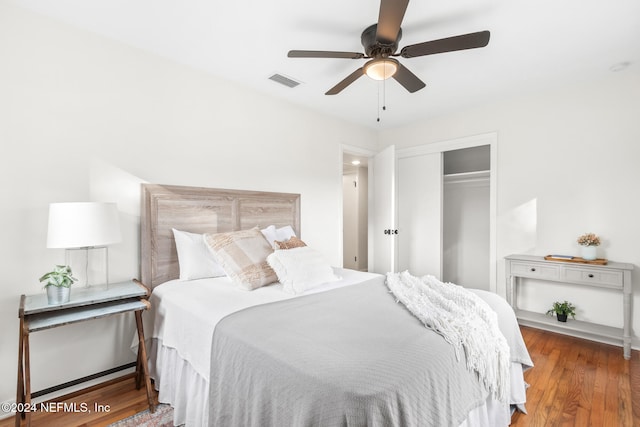 bedroom with ceiling fan, wood-type flooring, and a closet