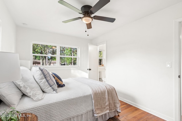 bedroom featuring hardwood / wood-style floors, ceiling fan, and ensuite bath