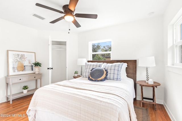 bedroom with a closet, hardwood / wood-style flooring, and ceiling fan