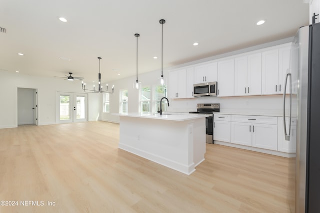 kitchen featuring an island with sink, white cabinets, light wood-type flooring, and appliances with stainless steel finishes