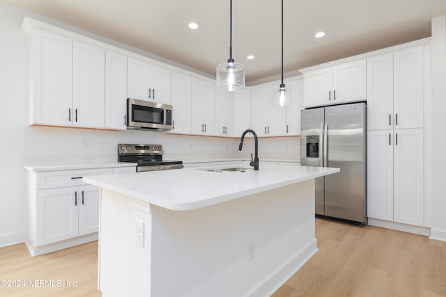 kitchen featuring white cabinetry, hanging light fixtures, and stainless steel appliances