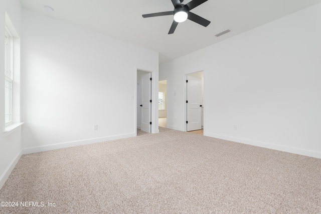 unfurnished room with ceiling fan and carpet