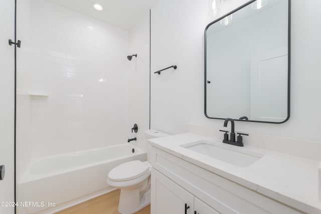 full bathroom featuring tiled shower / bath, hardwood / wood-style flooring, toilet, and vanity