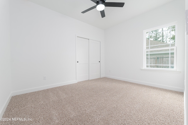 unfurnished bedroom featuring carpet flooring, ceiling fan, and a closet