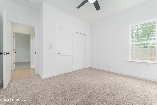 unfurnished bedroom with ceiling fan, a closet, and carpet floors