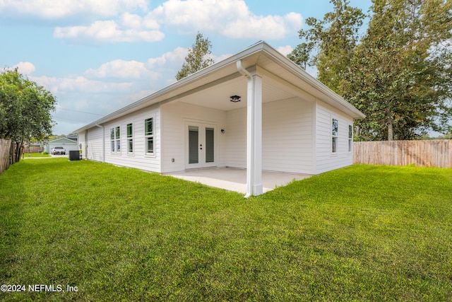 rear view of house featuring french doors, a lawn, and a patio