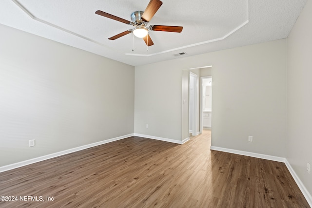 empty room with a textured ceiling, hardwood / wood-style flooring, and ceiling fan