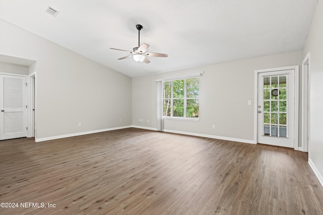 unfurnished room with ceiling fan, wood-type flooring, a healthy amount of sunlight, and lofted ceiling