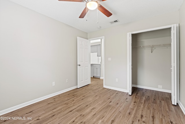 unfurnished bedroom with a closet, light wood-type flooring, and ceiling fan