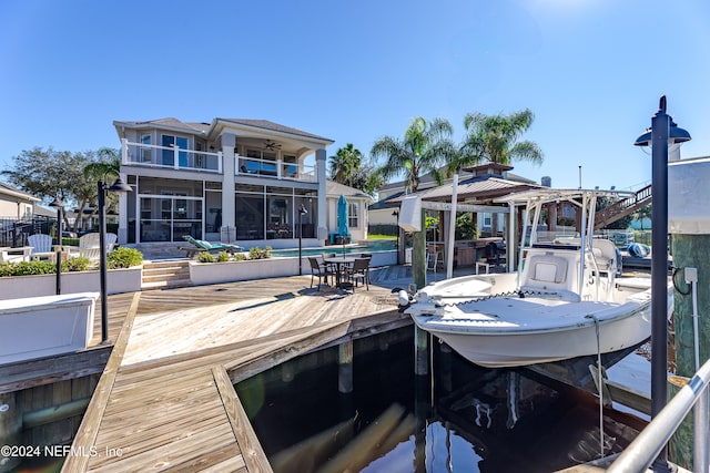 dock area featuring a balcony and a swimming pool