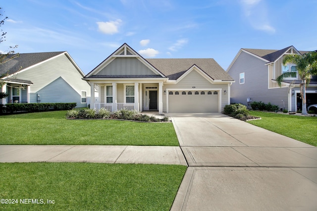 view of front of home with a front yard, a porch, and a garage