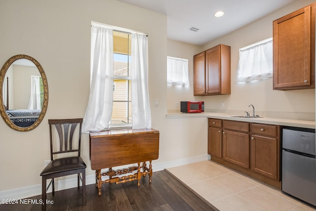 kitchen featuring light hardwood / wood-style floors, stainless steel refrigerator, and sink