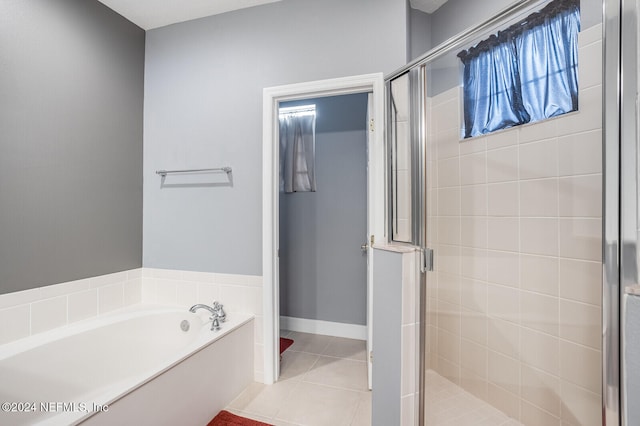 bathroom with separate shower and tub and tile patterned flooring