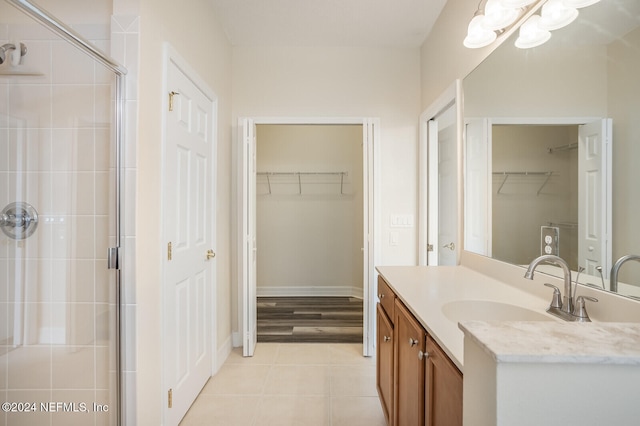 bathroom featuring hardwood / wood-style floors, vanity, a shower with shower door, and an inviting chandelier