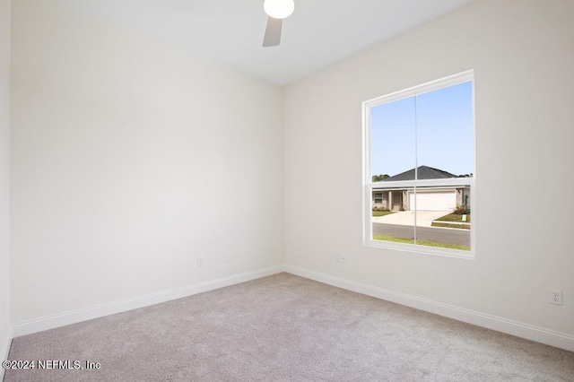 spare room featuring light colored carpet and ceiling fan