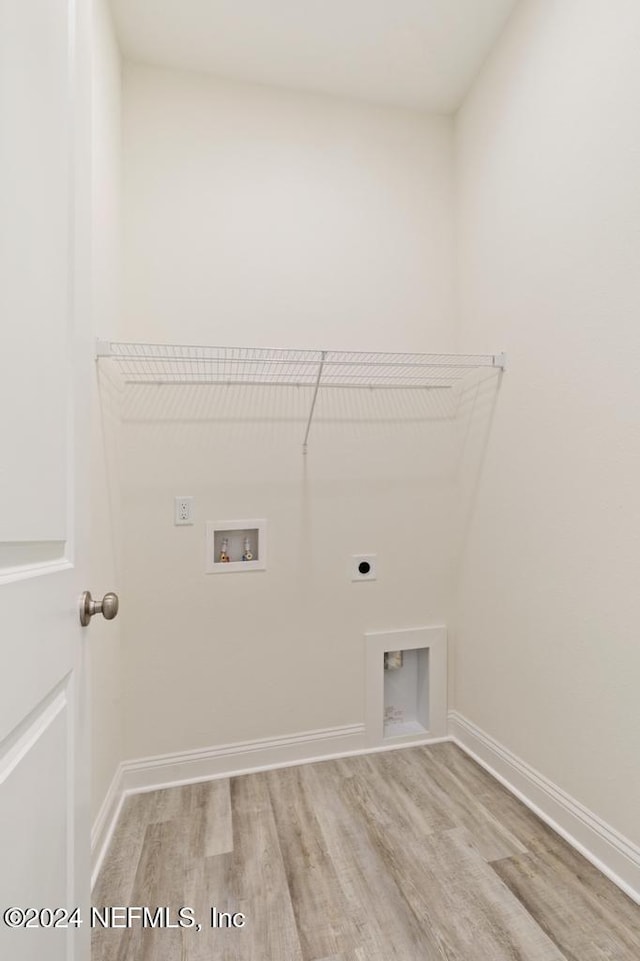 clothes washing area featuring light hardwood / wood-style floors, electric dryer hookup, and washer hookup