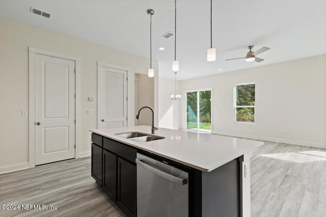 kitchen with light hardwood / wood-style floors, a center island with sink, sink, stainless steel dishwasher, and hanging light fixtures