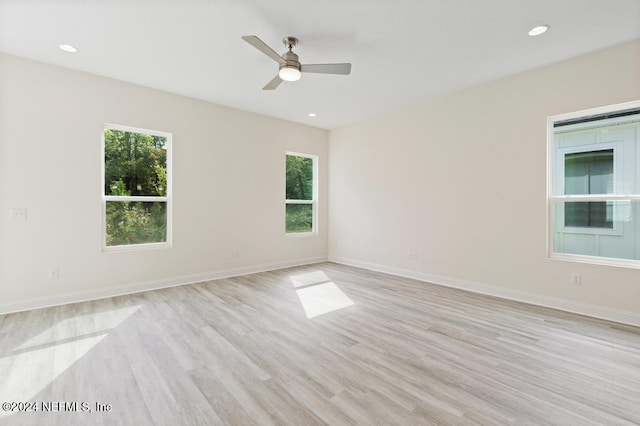 empty room with ceiling fan and light hardwood / wood-style floors