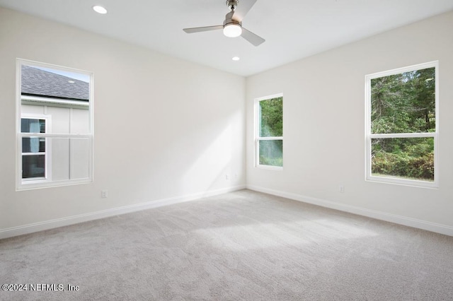 carpeted spare room with ceiling fan