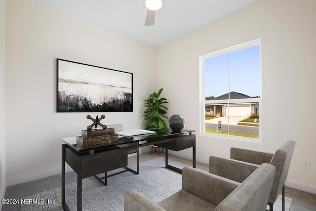 carpeted office space featuring ceiling fan