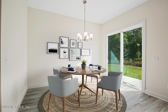 dining room with hardwood / wood-style floors and an inviting chandelier