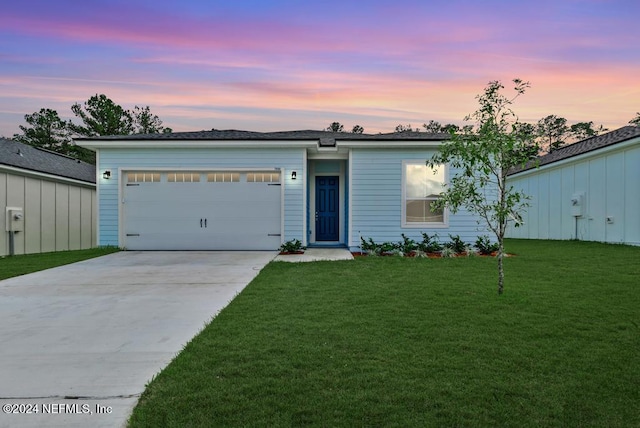 ranch-style home with a garage and a lawn