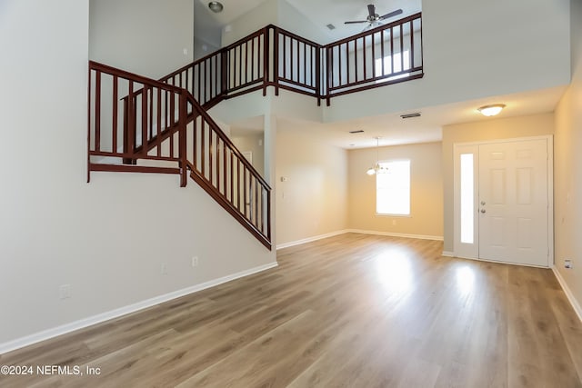 12229 Mastin Cove Rd, Jacksonville, FL 32225 - unfurnished living room featuring stairs, ceiling fan, wood finished floors, baseboards, and a towering ceiling