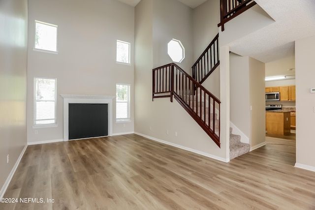 12229 Mastin Cove Rd, Jacksonville, FL 32225 - foyer with a high ceiling, light wood-style flooring, stairway, and baseboards