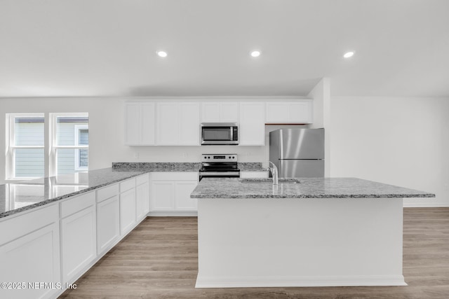 37343 Whisper Way, Hilliard, FL 32046 - kitchen featuring appliances with stainless steel finishes, light stone countertops, white cabinetry, a center island with sink, and recessed lighting